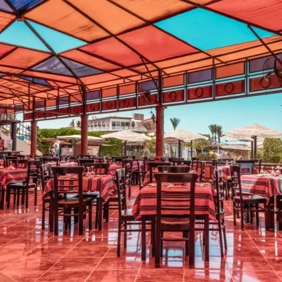 terrasse du snack bar avec chaises en bois et tables dressé en rouge