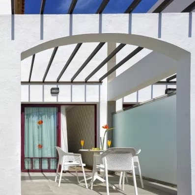 Une terrasse privative ombragée par une pergola, idéale pour prendre un verre en extérieur.