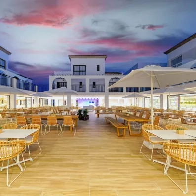 Une vaste salle de restauration en plein air sous un ciel de fin de journée.