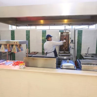 Chef cuisiner derrière le comptoir du restaurant préparant du Kebab  