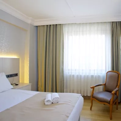 chambre avec un grand lit double et un fauteuil