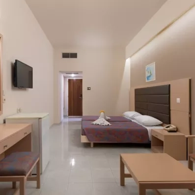 Chambre double avec deux lits collés, TV, réfrigérateur et coiffeuse