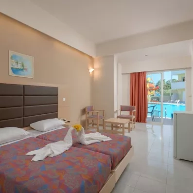 Chambre double avec deux lits collés  avec une porte fenêtre directement sur la piscine  