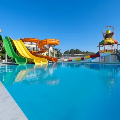 La piscine extérieur avec toboggans colorés et un ciel bleu