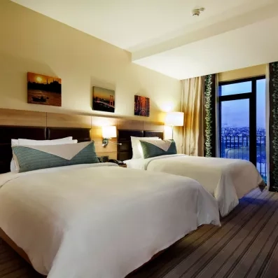 chambre avec deux lits simples et un balcon