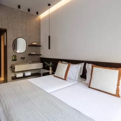 Chambre de l'hôtel avec grand lit, un lavabo, miroir et des serviettes 