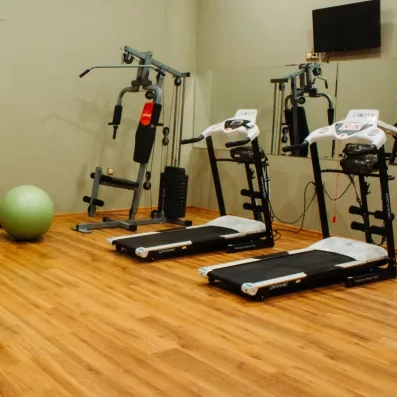 Une salle de sport équipée de tapis de course et de machines de musculation.