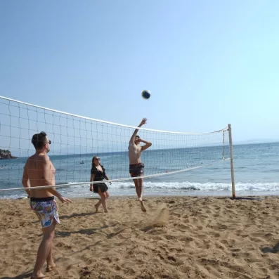 Un groupe de personnes jouant au volley-ball sur une plage au bord de la mer.