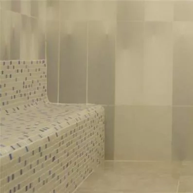 Une hammam aux parois carrelées de mosaïques dans des tons sobres et apaisants.