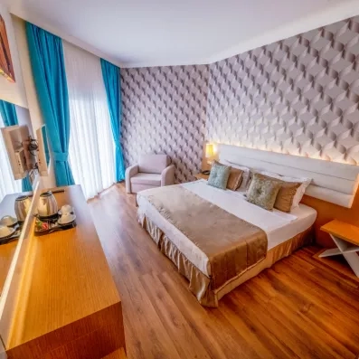 Une chambre lumineuse avec un lit double et des rideaux bleu turquoise.