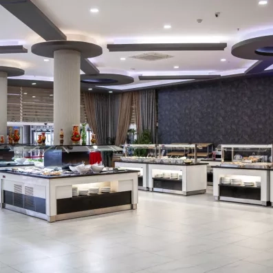 Un buffet d'hôtel moderne, avec plusieurs aliments chauds et froids installées sur un comptoir.