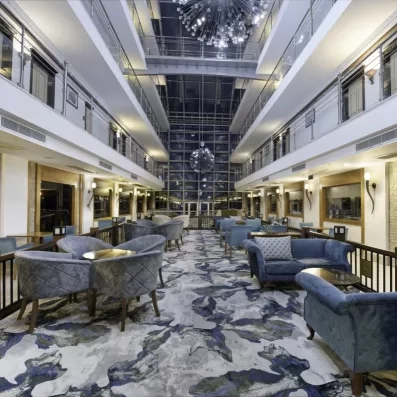 hall d'entrée avec coin salon équipé de fauteuils et de canapés