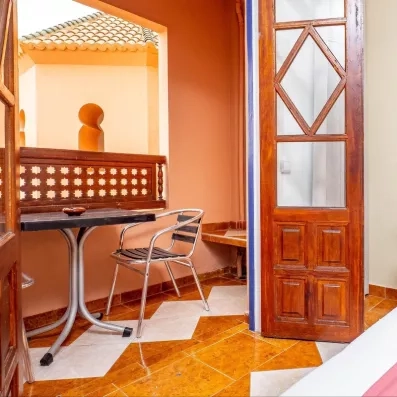 Balcon de la chambre avec une table et deux chaises pour profiter du soleil