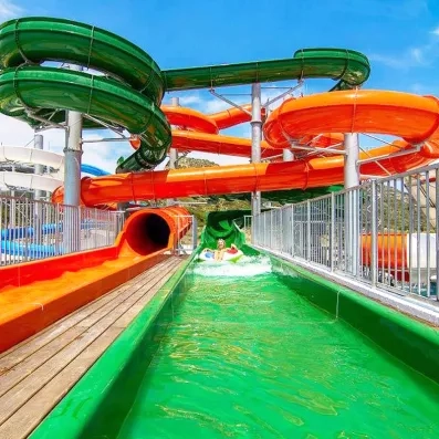 toboggans vert et orange, femme dans une bouée qui glisse, barrières de protection