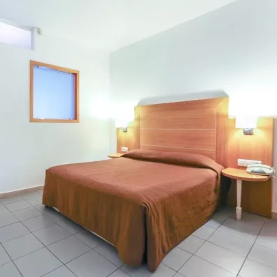 Chambre confortable, Lit double marron, lumière, téléphone, fenêtre salle de bain  