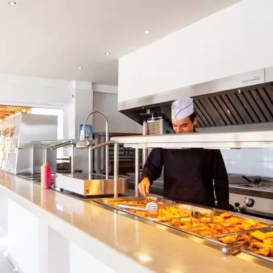 Comptoir du buffet au restaurant, chef cuisinier, plats chauds, frites, ketchup moutarde