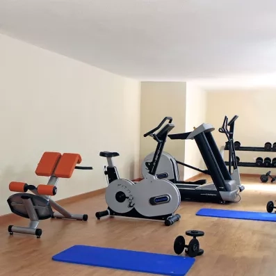 Un espace de fitness équipé de vélos, d'un tapis de course et de tapis de sol.