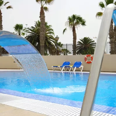 Un col de cygne déversant une fontaine d'eau relaxante dans un bassin bleu.