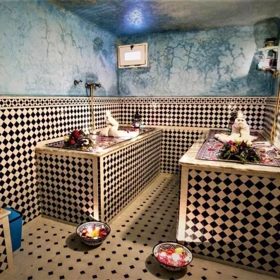 chambre chaude du hammam traditionnel marocain avec deux table de gommage en marbre