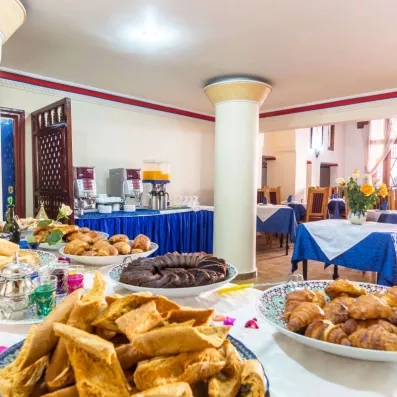 Salle du petit déjeuner sous forme de buffet avec des viennoiseries et des boissons