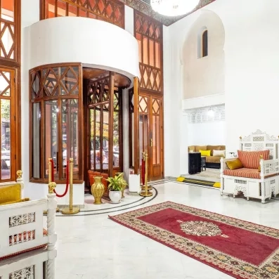 hall d'entrée de l'hôtel avec un tapis traditionnel au milieu en rouge et des fauteuils 