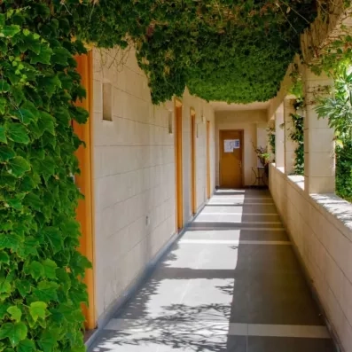 couloir extérieur des chambres avec ouverture sur végétation 