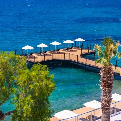 vue de loin du ponton de l'hôtel avec des transats et des parasols