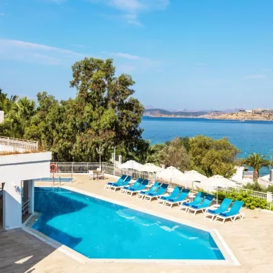 piscine avec transats et parasols vue sur la mer au loin