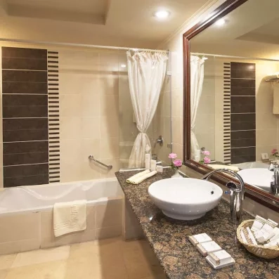 Salle de bain moderne avec baignoire et produits d'accueil, confort hôtelier au complexe Stella Garden Égypte.