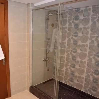 Salle de bain moderne avec douche à l'italienne et carrelage mosaïque design au Stella Beach Resort.
