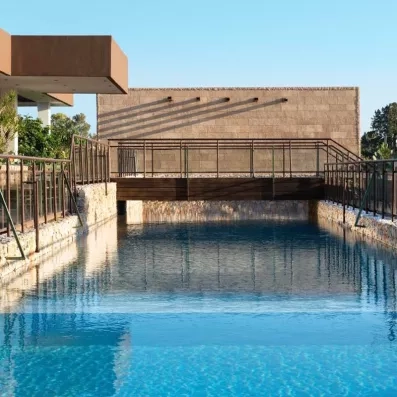 piscine extérieur avec un pont en bois qui traverse avec le bâtiment de l'hôtel 