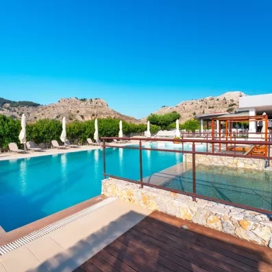 piscine avec transat  et des parasols autour et une vue sur la montagne 