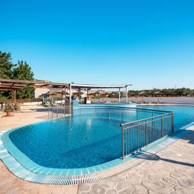 Piscine pour adultes et piscine pour enfant protégée par des barres et des transats autour
