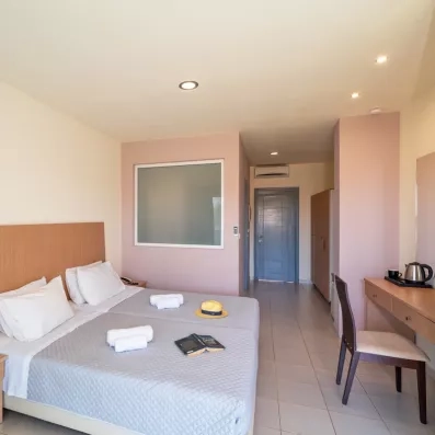 chambre classique avec un grand lit deux places, une coiffeuse avec chaise confortable