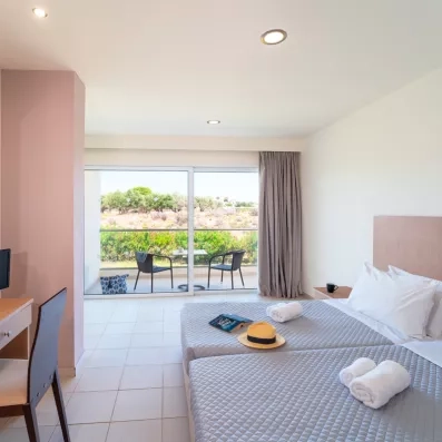 Chambre avec deux lits doubles collés, une baie vitré  qui donne sur la terrasse 