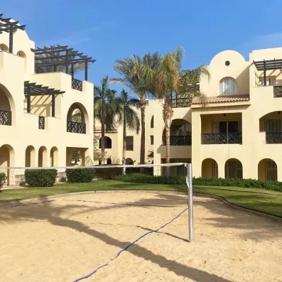 Terrain de beach-volley sur sable entouré de jardins au complexe hôtelier Stella Garden, Egypte.