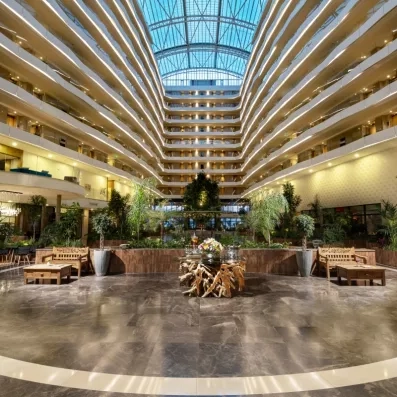 Un hall intérieur monumental et lumineux, entouré de nombreux étages de balcons.