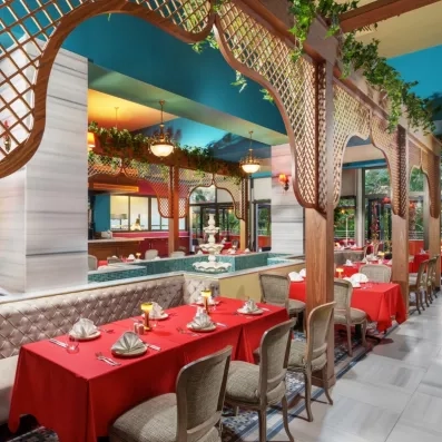 Un intérieur de restaurant élégant aux accents orientaux avec une petite fontaine centrale.