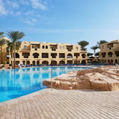 Grande piscine bleue et bâtiments ocre au Mondi Club Stella Garden, séjour balnéaire à Hurghada, Égypte.