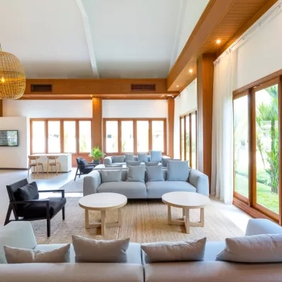 Un salon spacieux et confortable avec des canapés et de grandes baies vitrées ouvrant sur l'extérieur.