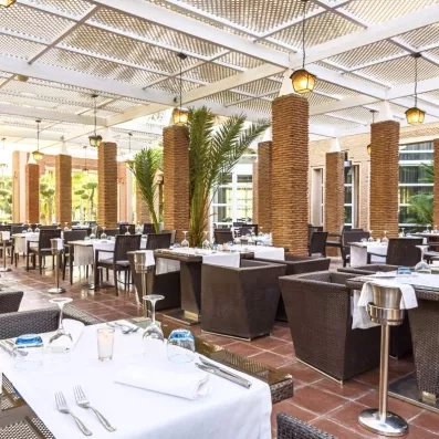 restaurant extérieur de l'hôtel avec table et chaise sur la terrasse avec de la verdure autour