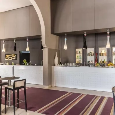 bar de l'hôtel avec des chaises hautes en rouge et blanc et des lampes en noir et blanc