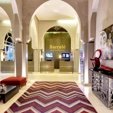 La réception de l'hôtel avec un meuble d'entrée à droite et un tableau juste en dessus, juste en face le bureau réception