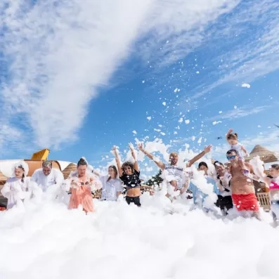 Des touristes qui profite d'une fête mousse à la piscine de l'hôtel