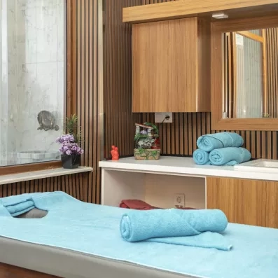 Une salle de soin équipée d'une table de massage recouverte de serviettes.