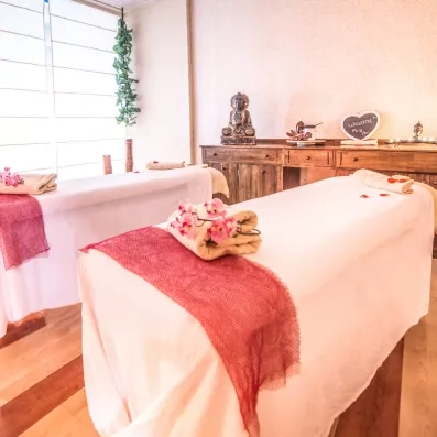 Une cabine de massage apaisante et lumineuse décorée avec des touches de fleurs roses.