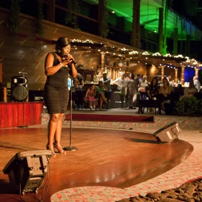 Une chanteuse se produisant sur une scène extérieure éclairée lors d'une soirée animée.