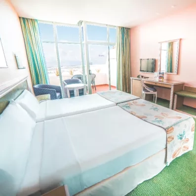 Une chambre confortable offrant une vue dégagée à travers une large baie vitrée.