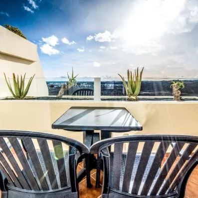 Une terrasse privée avec des chaises de jardin offrant une vue sur l'horizon.