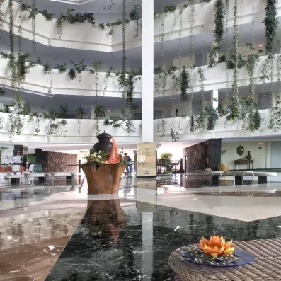 Le hall intérieur de l'hôtel moderne, vaste et lumineux, s'étendant sur plusieurs étages.